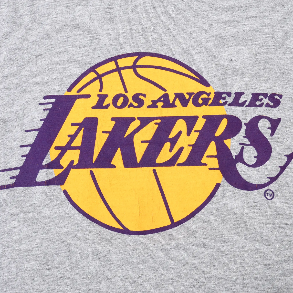 Close-up of purple and gold Los Angeles Lakers basketball logo printed on gray fabric