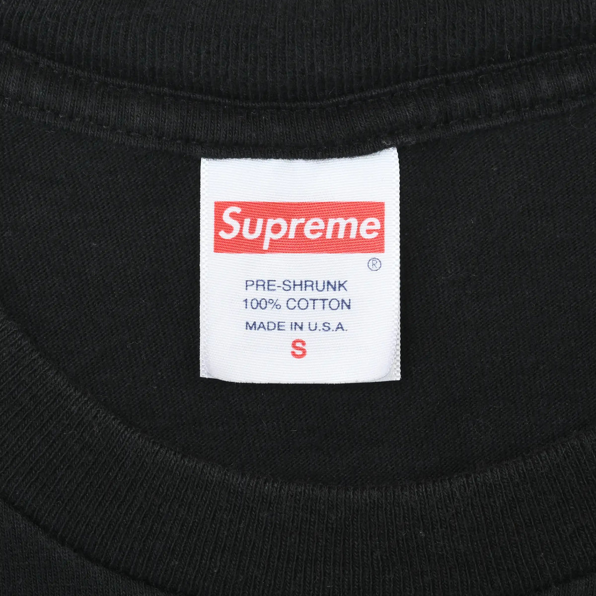 Supreme neck label showing pre-shrunk 100% cotton, Made in U.S.A., and size S