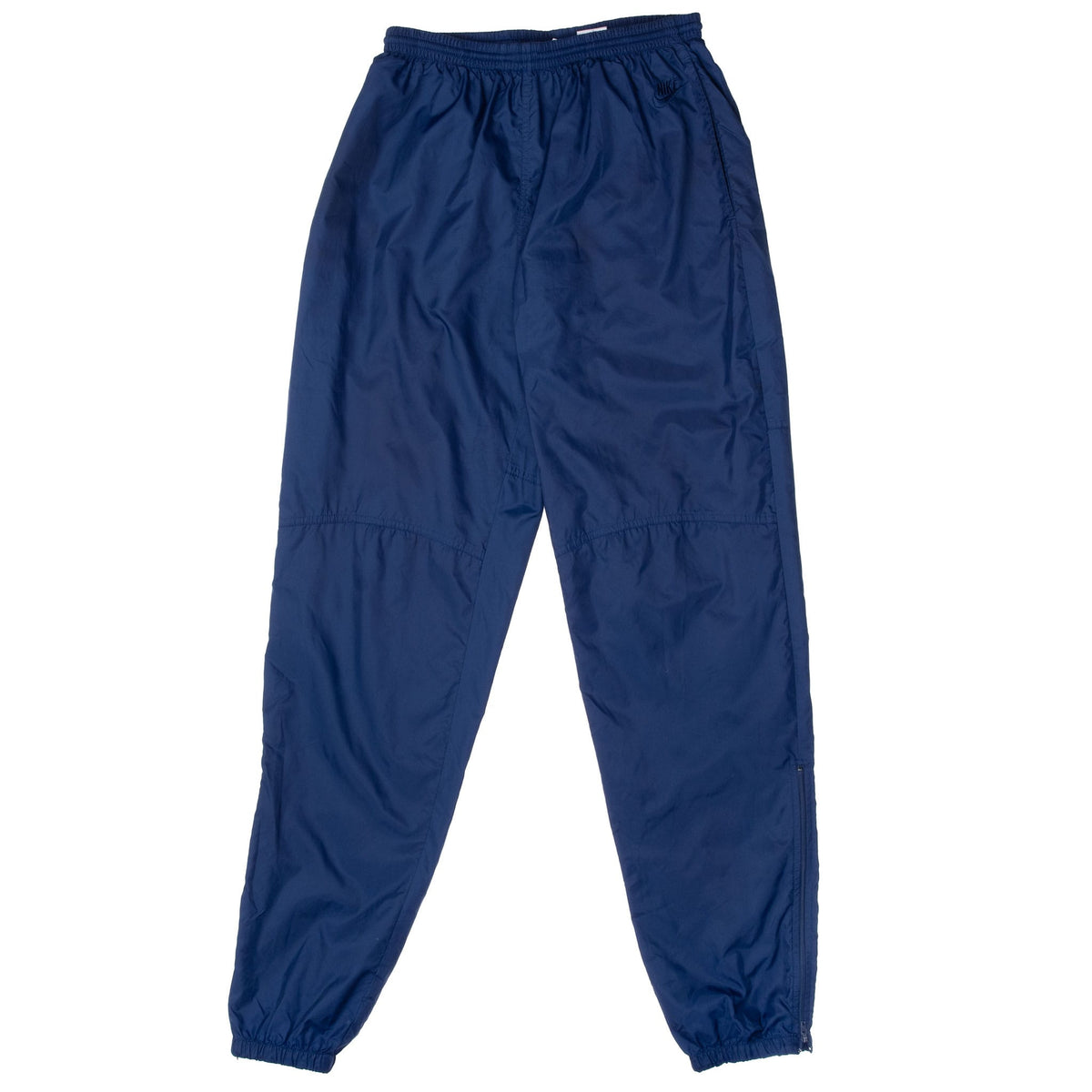 Front of navy blue Nike track pants with elastic waist, knee seams and cuffed ankles