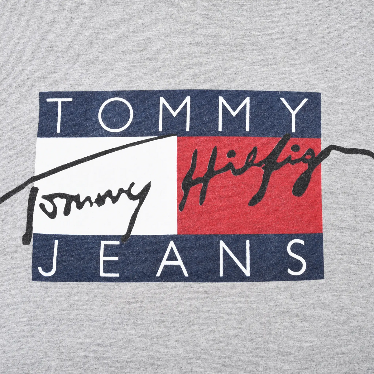 Close-up of Tommy Jeans chest graphic in navy, white, red and black on grey fabric