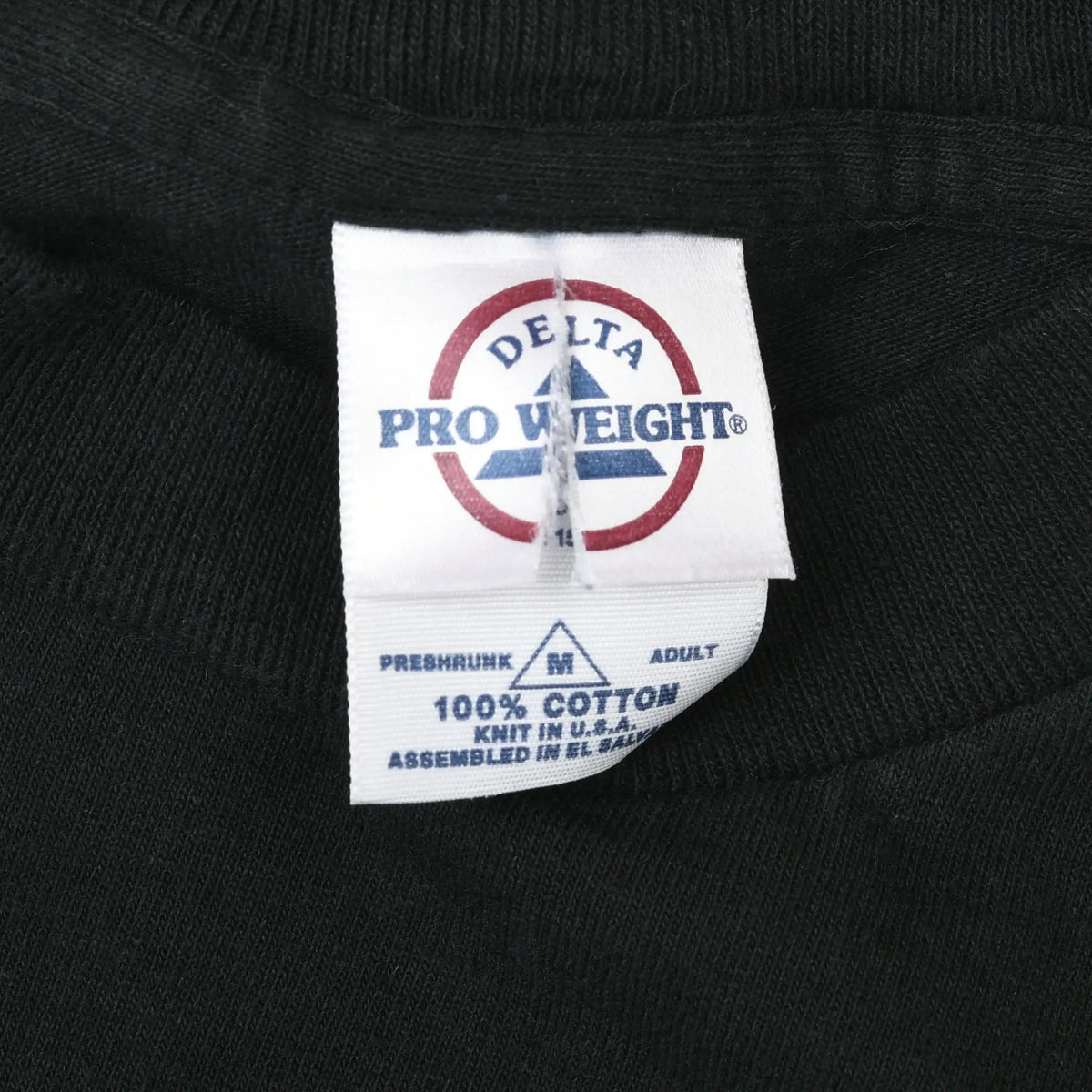 Close-up of Delta Pro Weight neck tag on black T-shirt