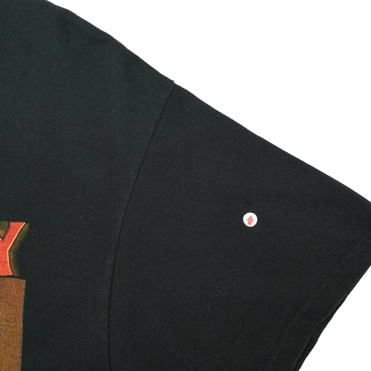 Close-up of black T-shirt sleeve showing a small hole