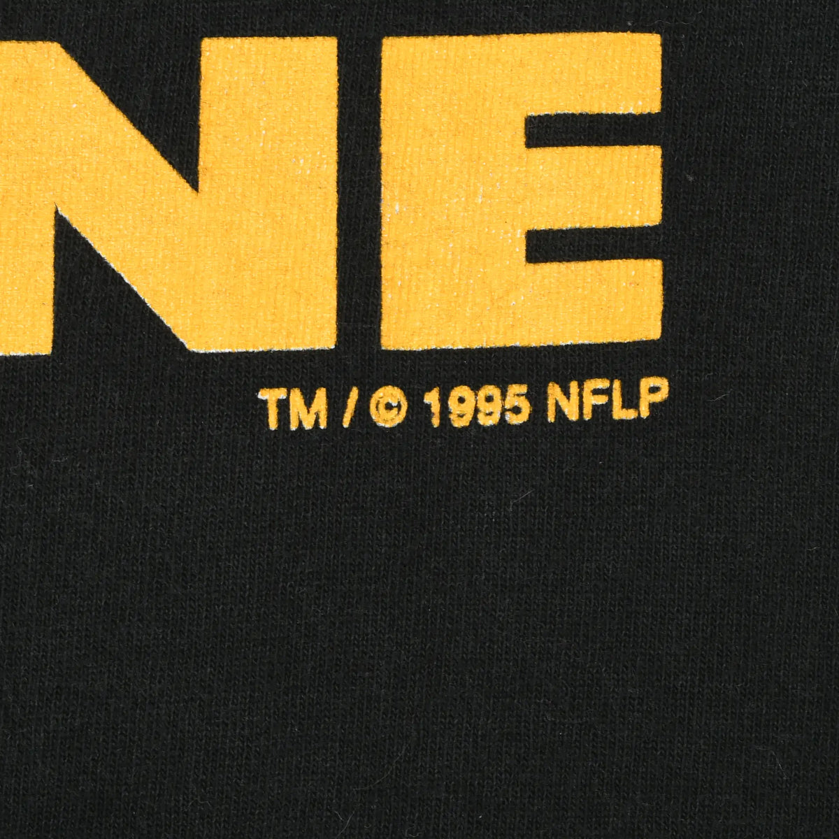 Close-up of 1995 NFLP copyright text beneath the gold Pro Line print