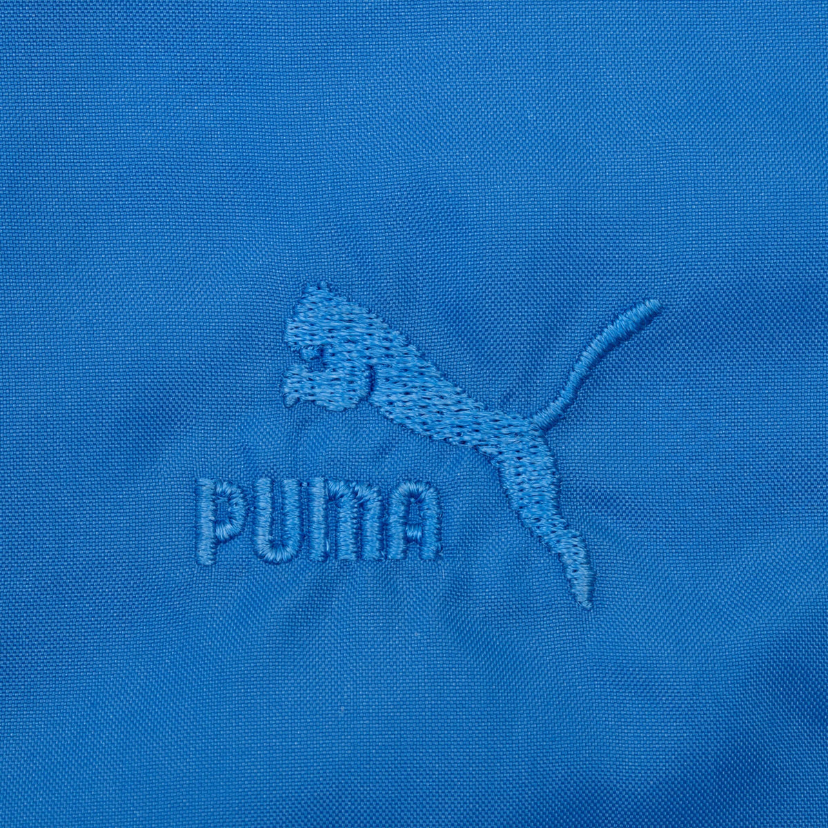 Tonal blue Puma cat logo and wordmark embroidered on jacket chest