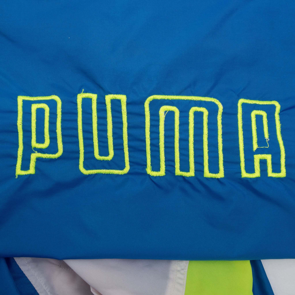 Neon yellow outlined Puma lettering embroidered on blue sleeve