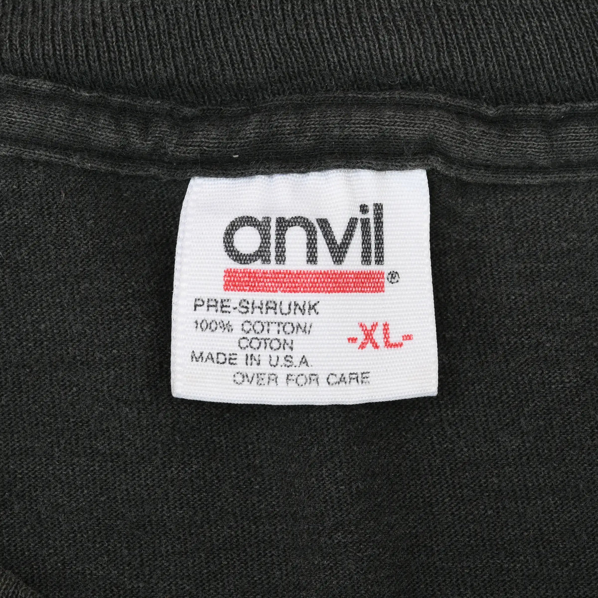 Close-up of Anvil XL neck tag stating pre-shrunk 100% cotton and made in USA