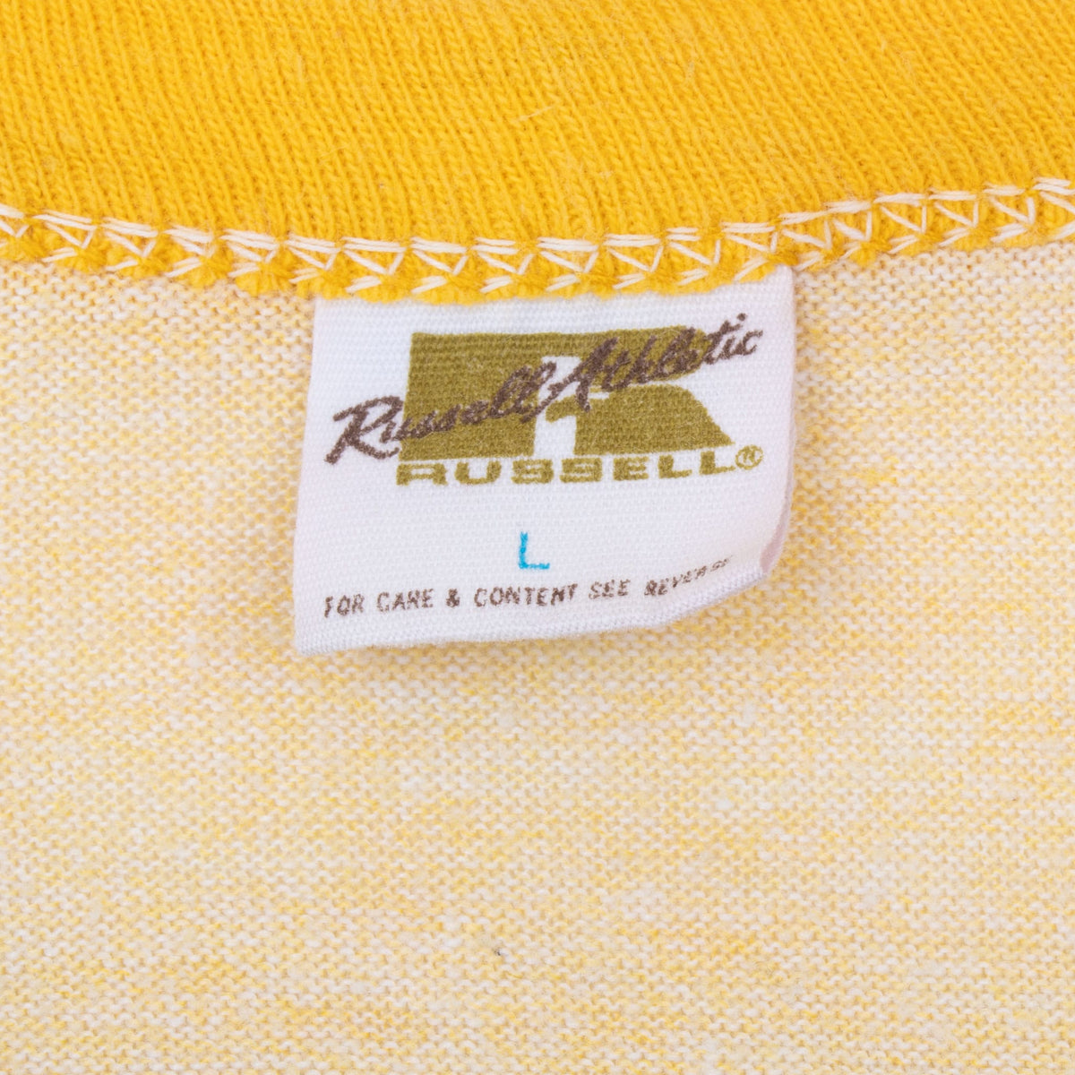 Close-up of Russell Athletic neck label marked L beneath yellow collar stitching