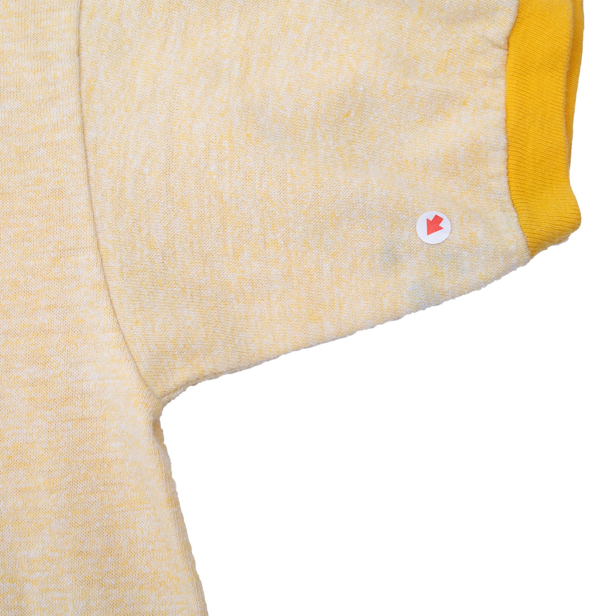 Sleeve and underarm detail with yellow cuff and marker indicating an area of wear