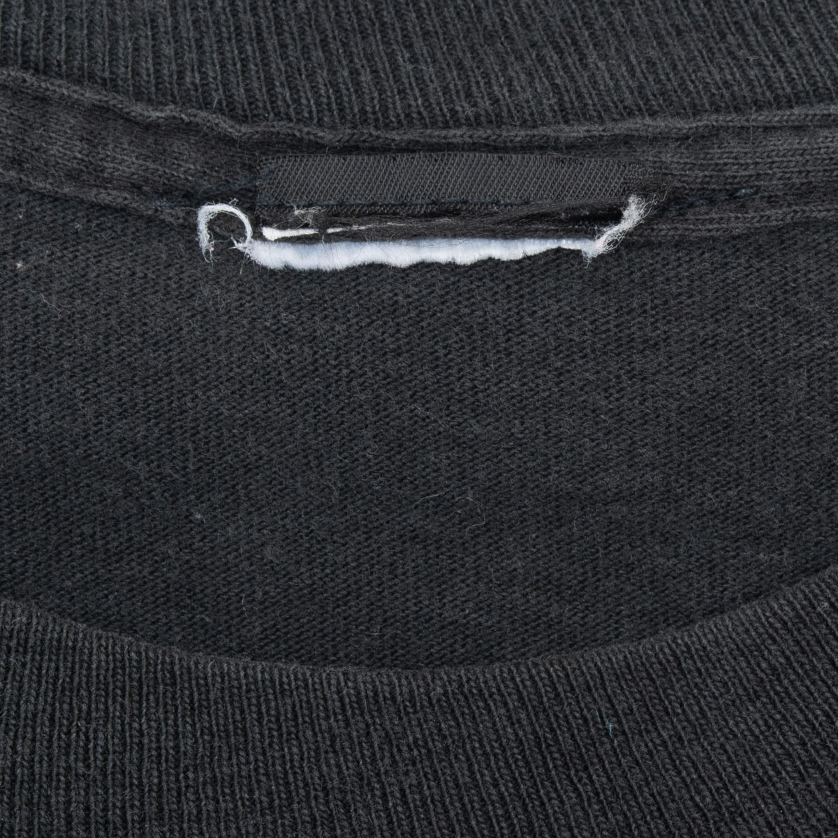 Inside collar detail of black Disney T-shirt with cut neck tag