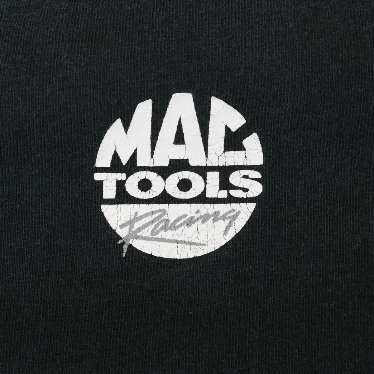 Close-up of white Mac Tools Racing back print on black fabric