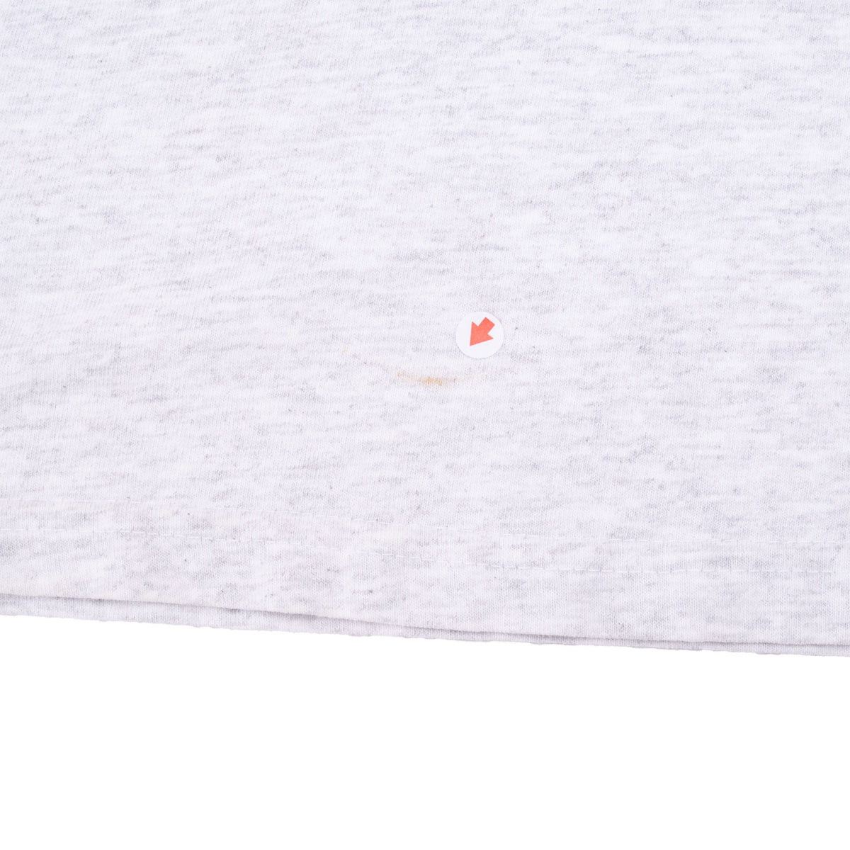 Close-up of a small faint mark near the hem of the gray T-shirt