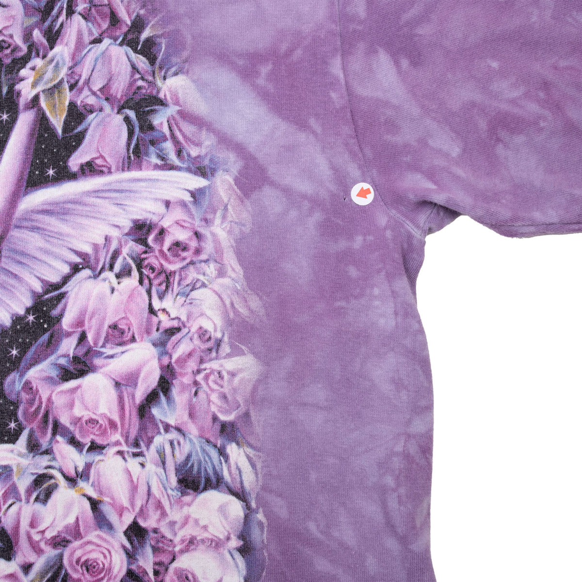 Close-up of small hole near right underarm beside the floral fairy graphic