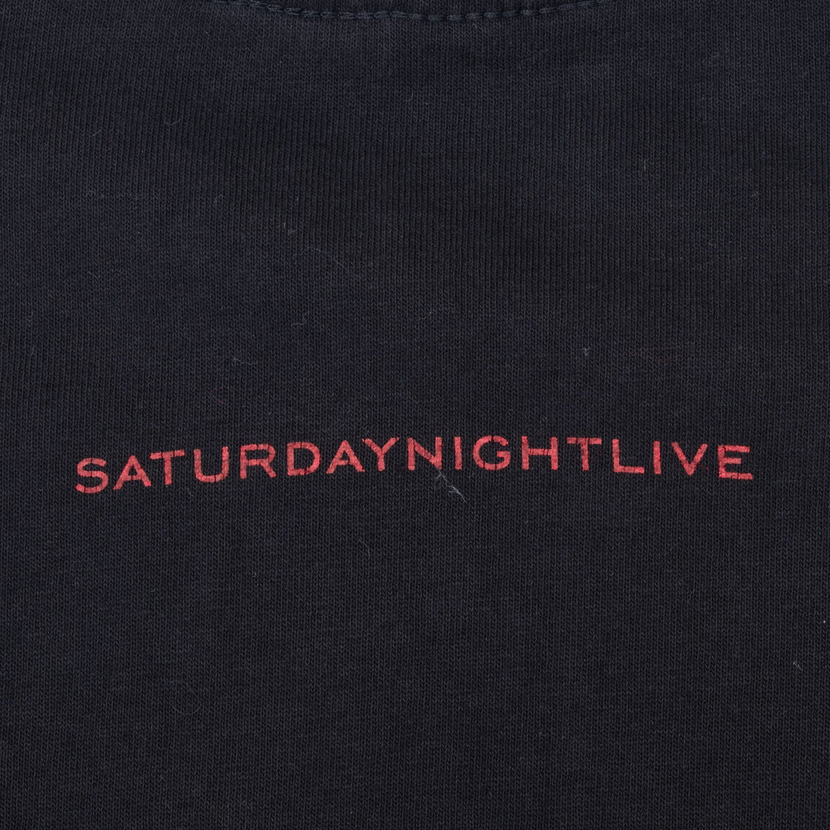 Close-up of small red Saturday Night Live print on the upper back