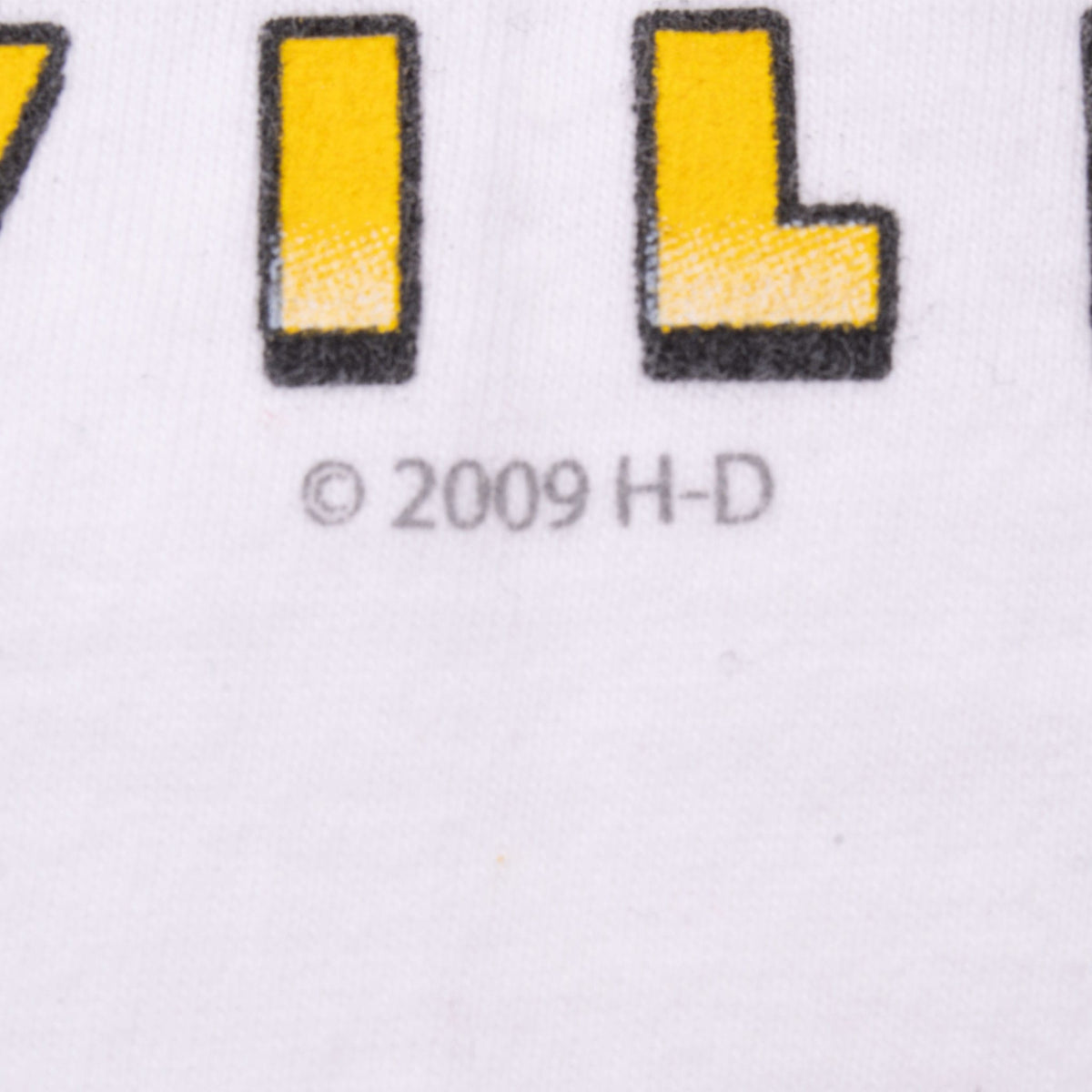 Close-up of 2009 H-D copyright mark beneath yellow lettering on back graphic