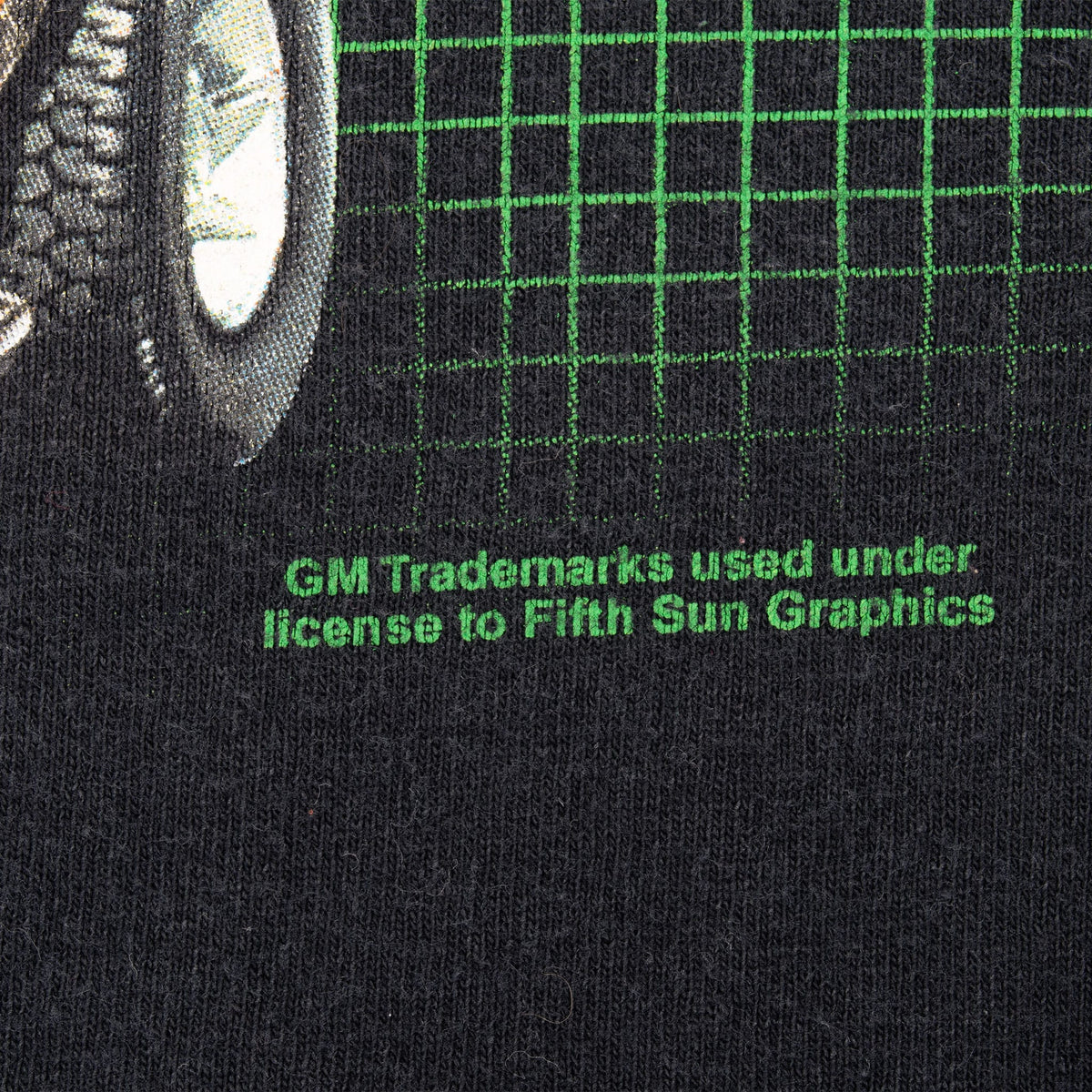 Close-up of green GM trademark licensing text beneath the back graphic