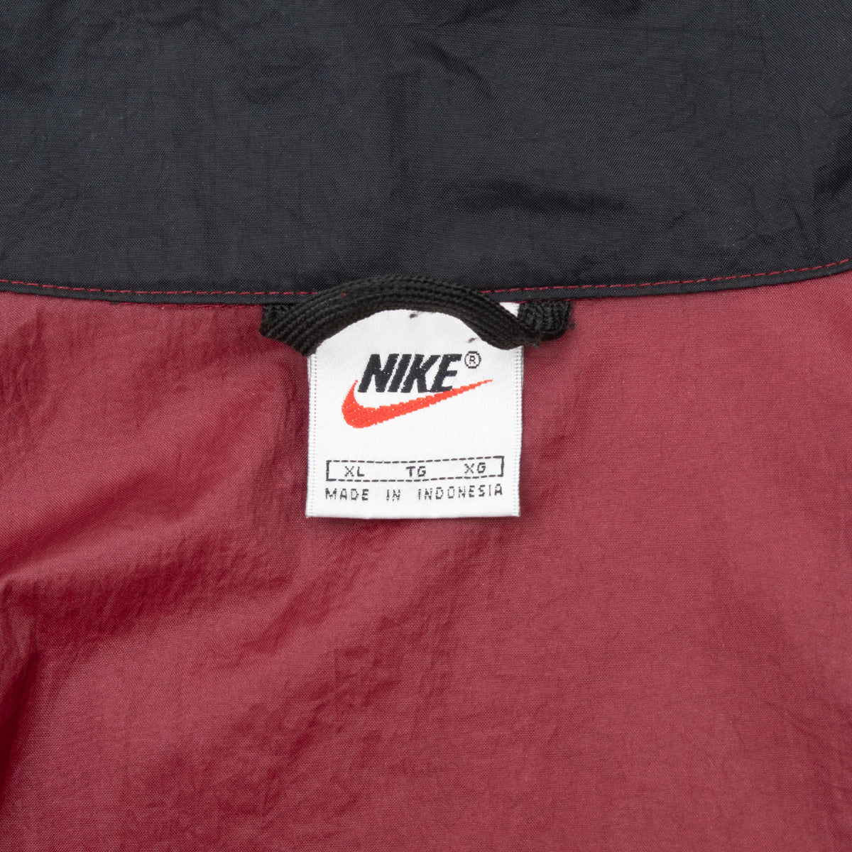 Nike neck label showing size XL inside burgundy windbreaker