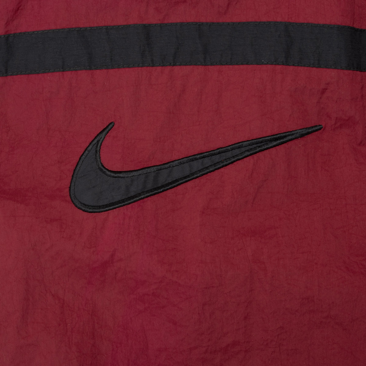 Large black Nike Swoosh detail on burgundy back panel