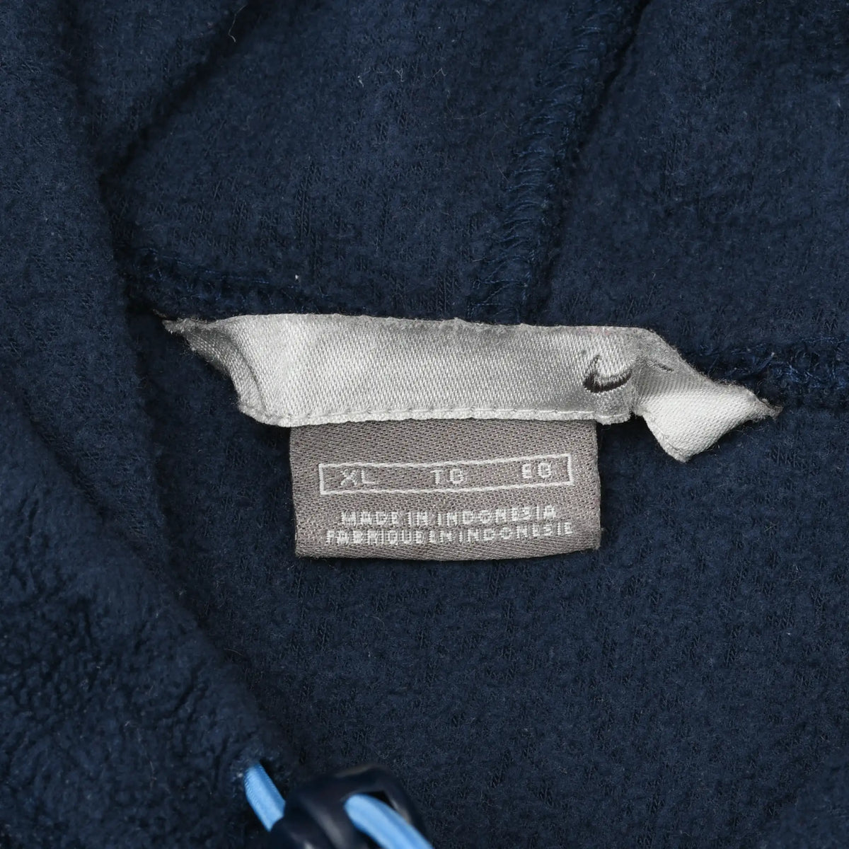Close-up of the Nike neck and care tags inside the navy fleece hoodie