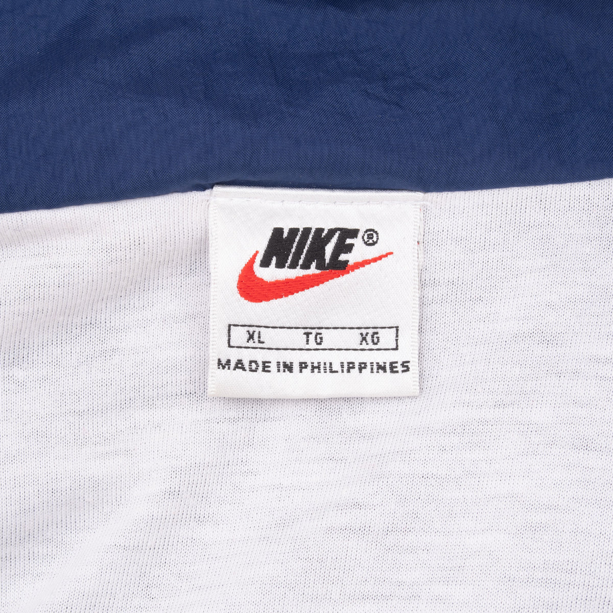 Nike neck label showing size XL on white jacket lining