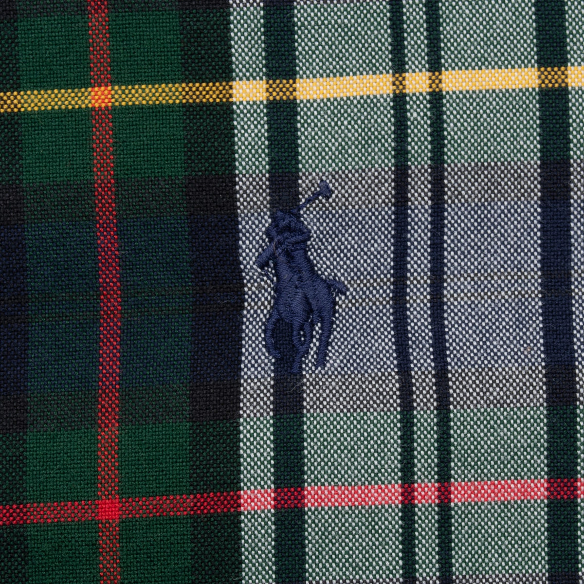Close-up of navy embroidered Polo pony logo on green and white plaid chest panel