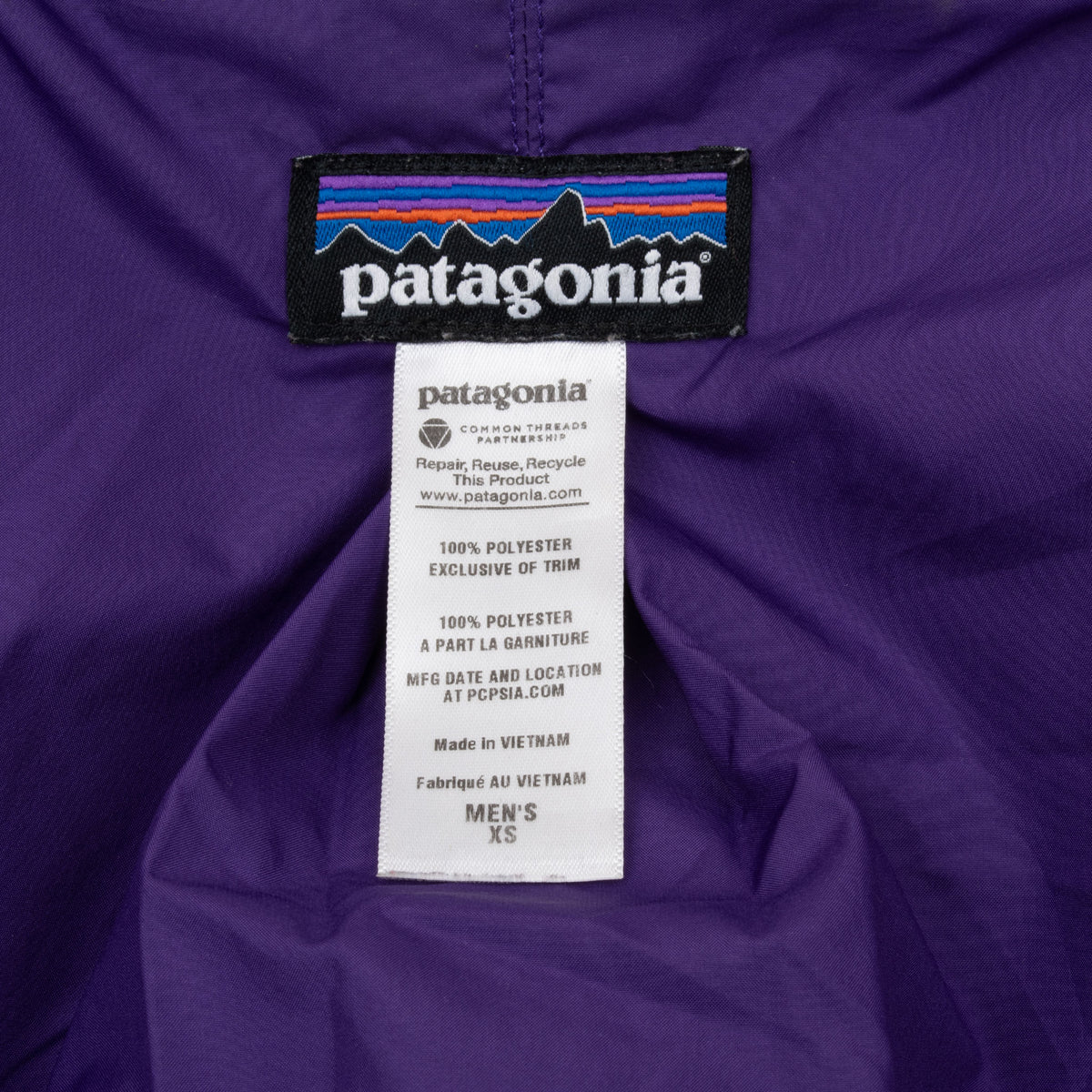 Patagonia neck and men's XS care labels on purple jacket lining
