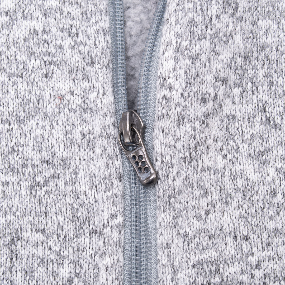 Close-up of front zipper pull and knit fleece texture on grey Patagonia vest