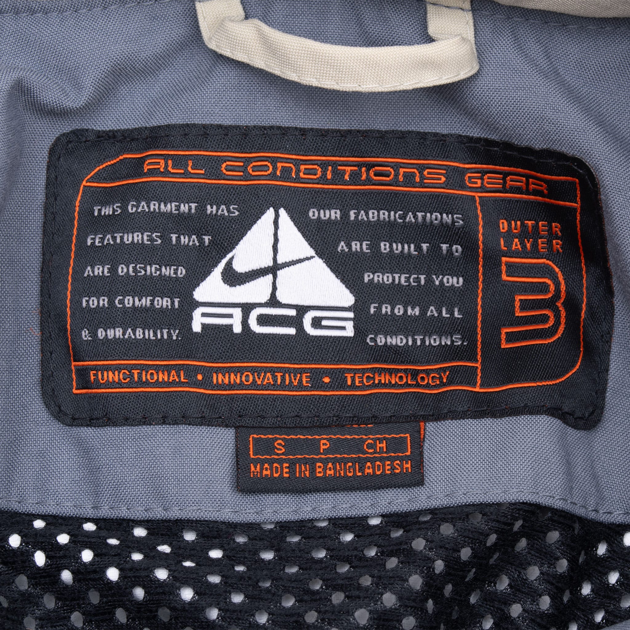 Close-up of Nike ACG All Conditions Gear interior label above black mesh lining
