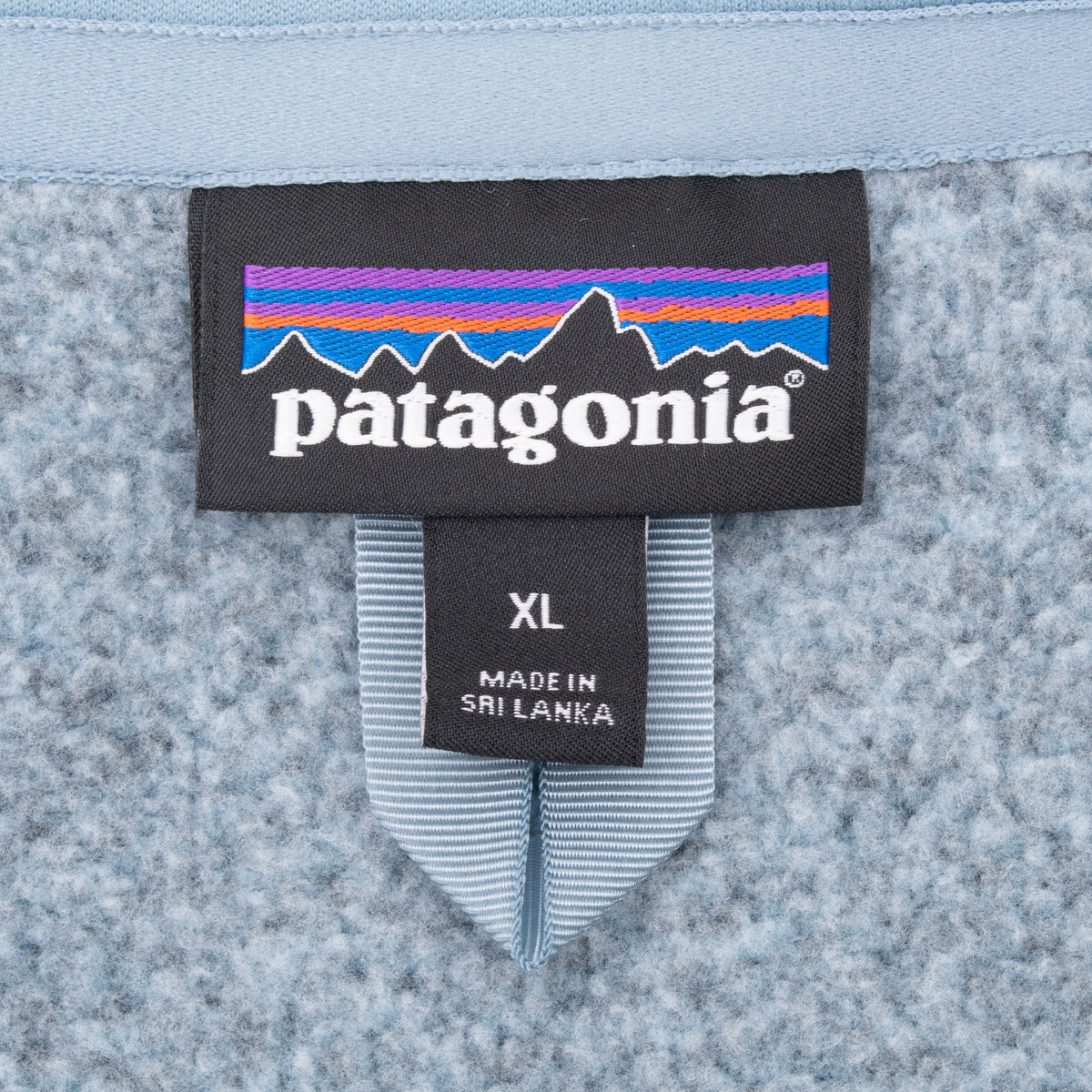 Patagonia neck label and women's XL size tag inside grey fleece vest