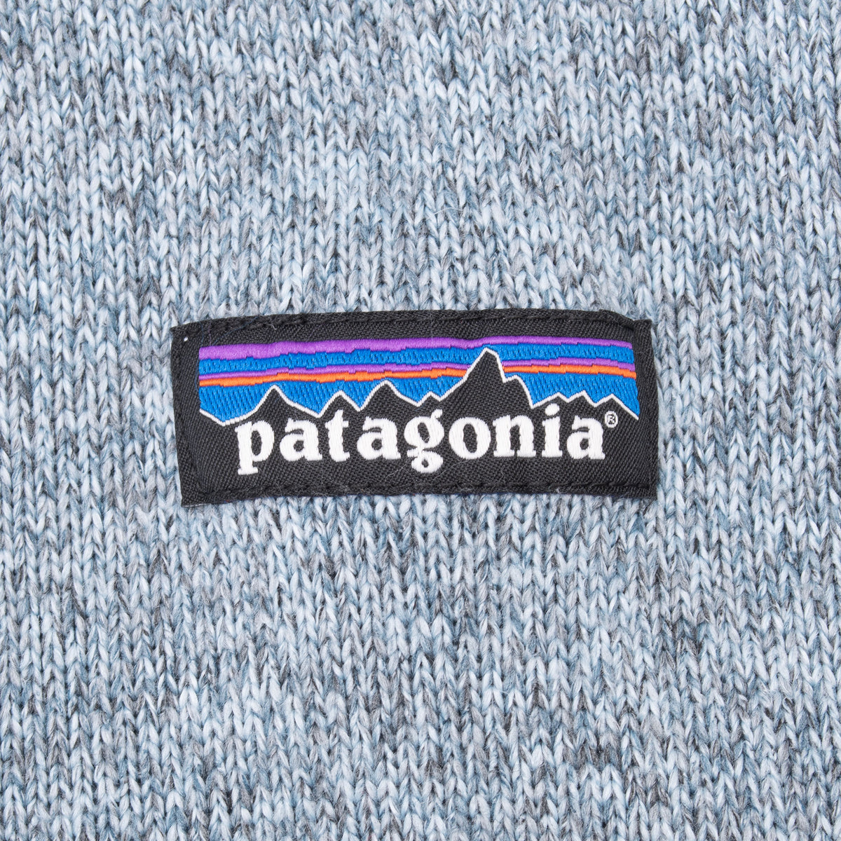 Close-up of Patagonia logo patch on grey knit fleece vest