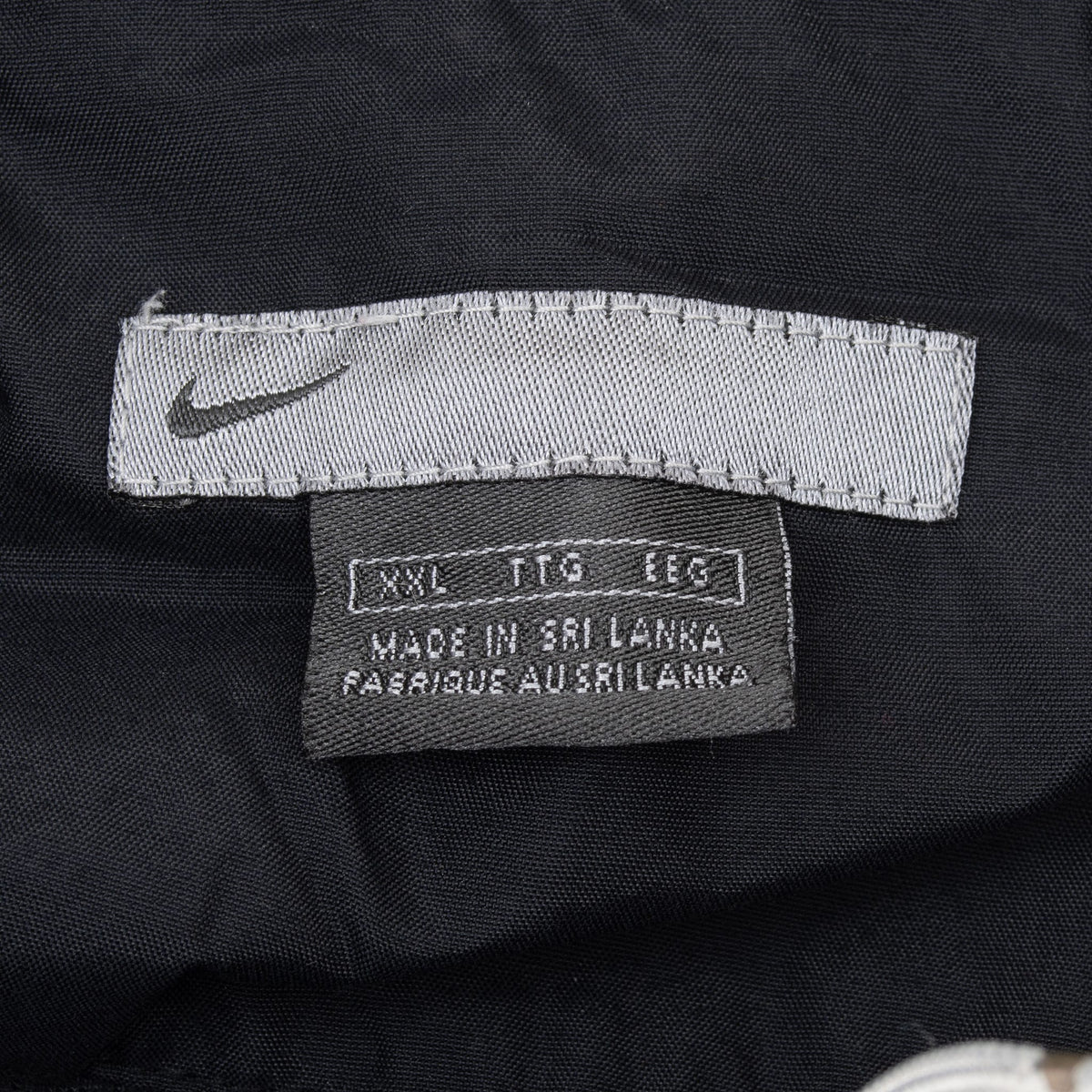 Nike neck label and size 2XL tag inside black windbreaker jacket