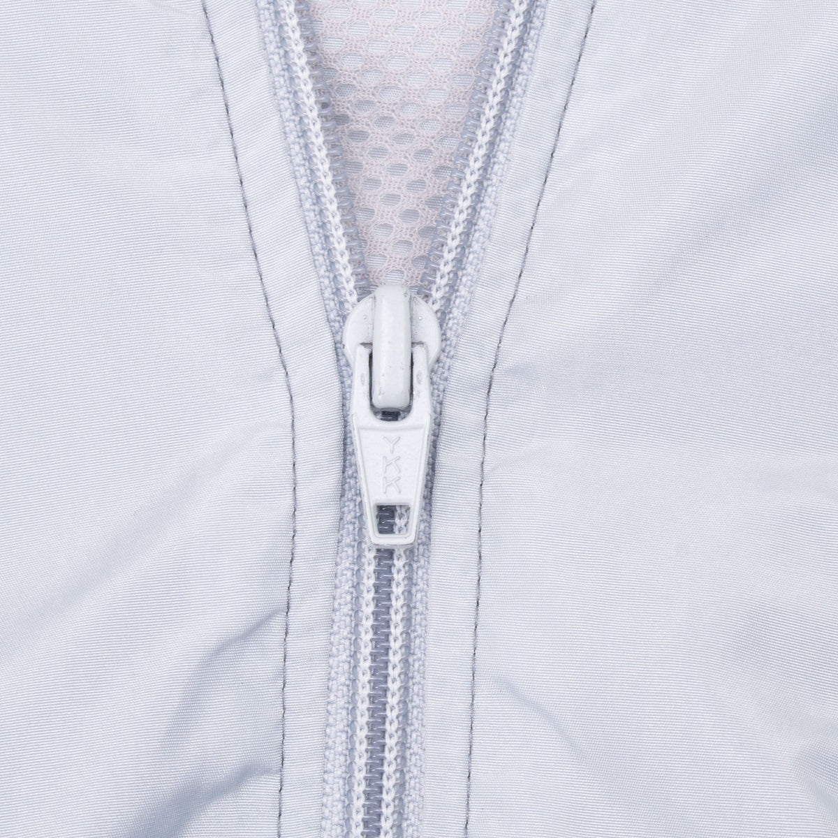 Close-up of the grey jacket's front zipper and YKK pull