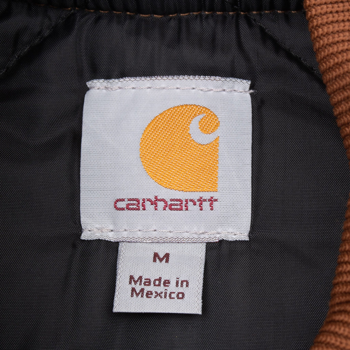 Carhartt neck label and size Medium tag on black vest lining