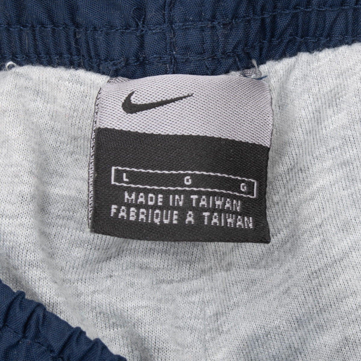 Nike size large waistband tag inside blue track pants