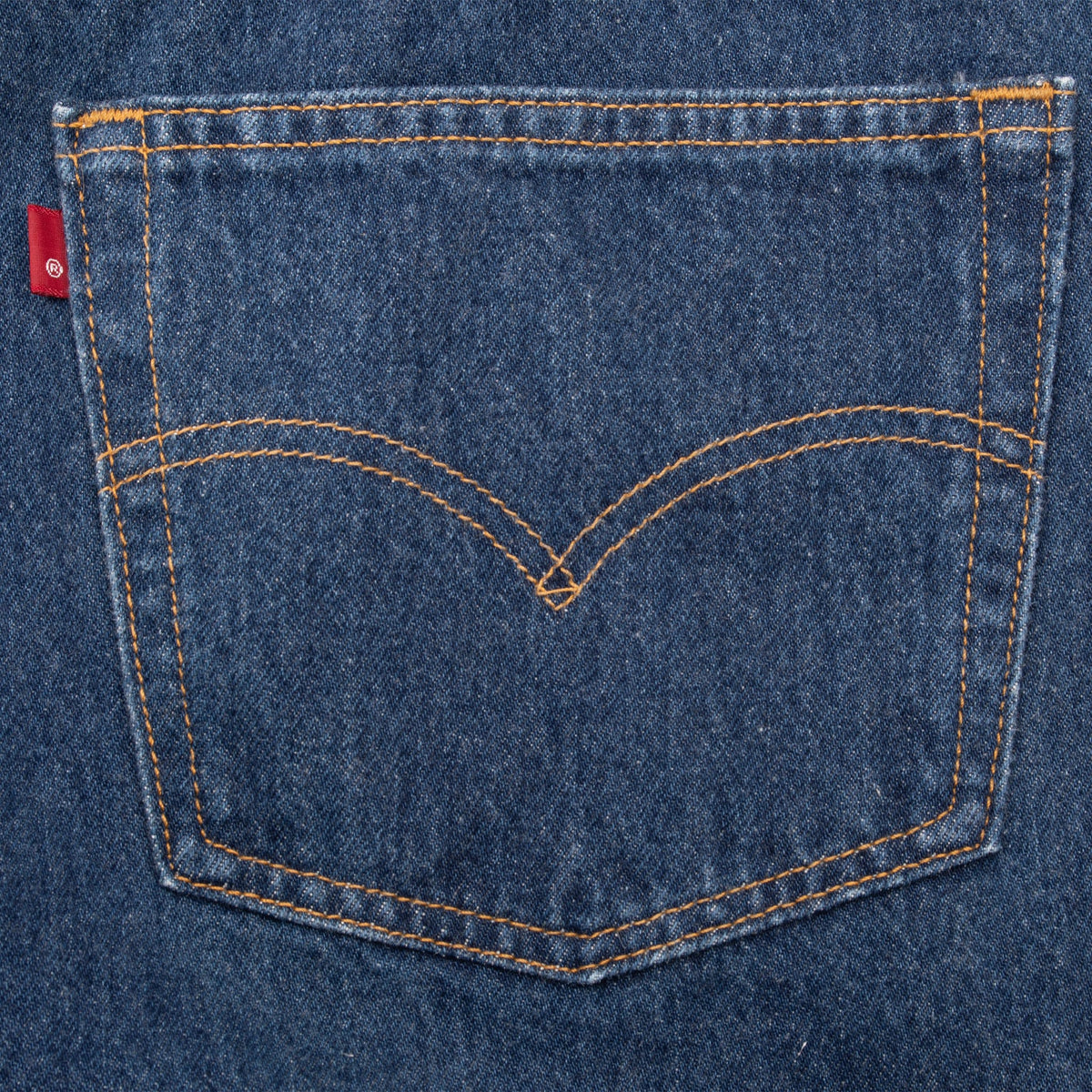 Levi's rear pocket detail with red tab and orange arcuate stitching on indigo denim