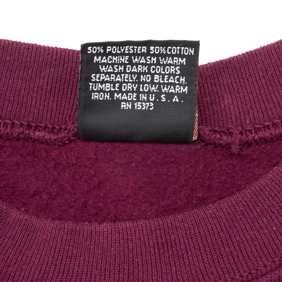 Sweatshirt care label showing 50% polyester, 50% cotton and made in USA