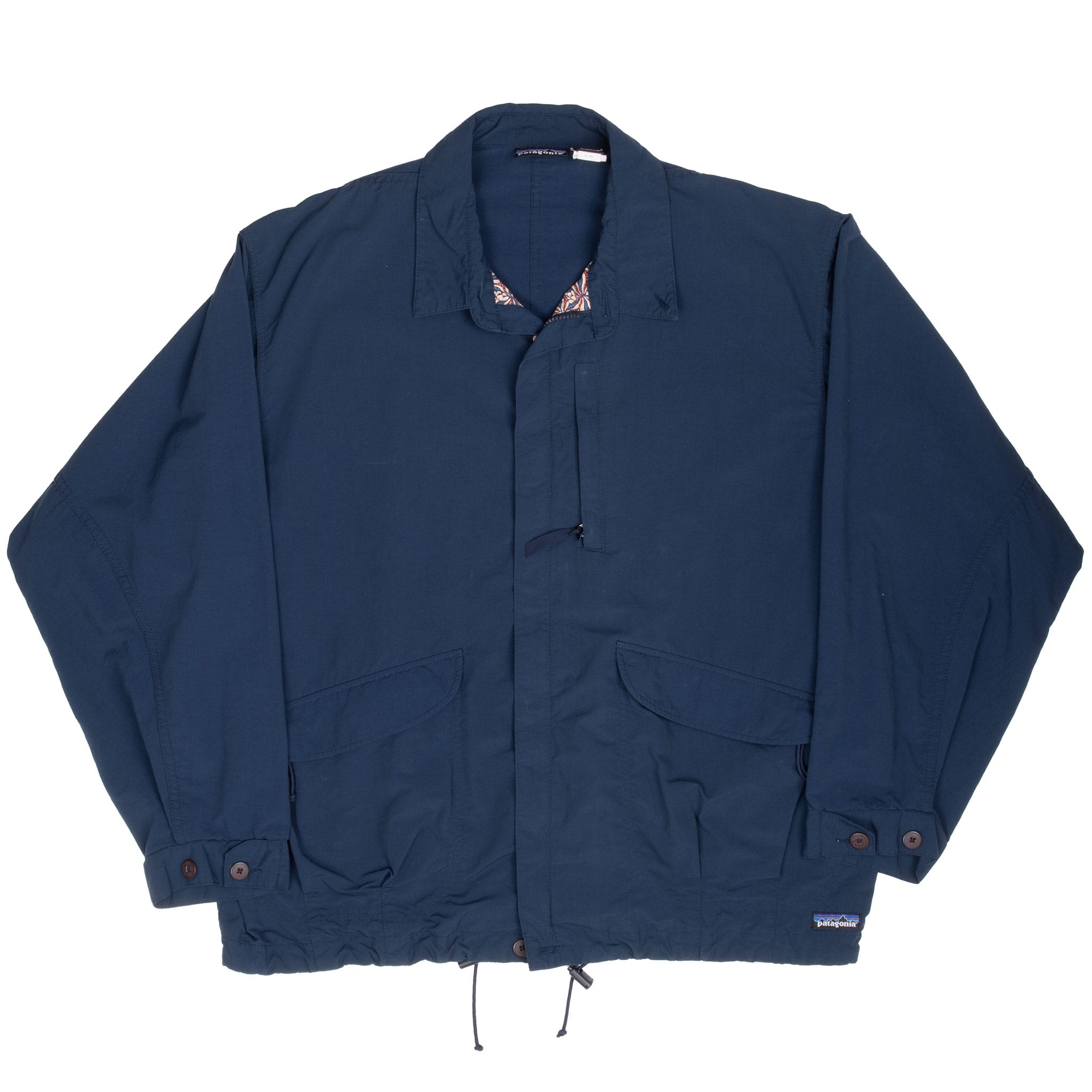 Front view of blue Patagonia windbreaker with flap pockets, buttoned cuffs and hem drawcords