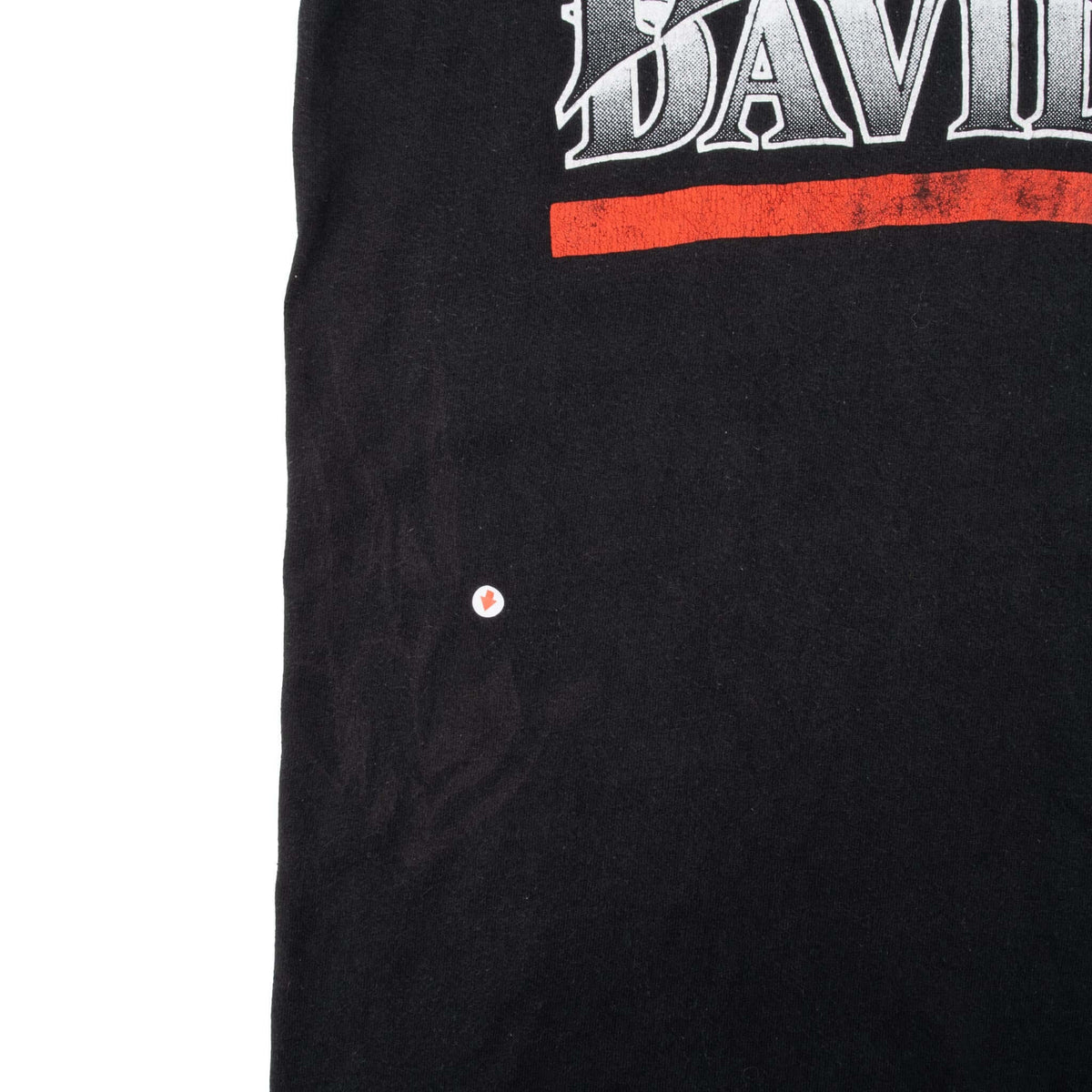 Close-up of black T-shirt front showing a small marked spot below the Harley-Davidson print
