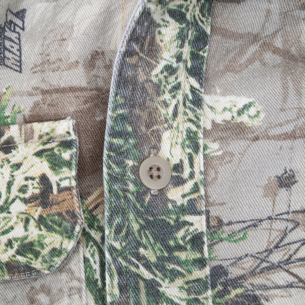 Close-up of chest pocket, button placket, and Advantage camouflage print