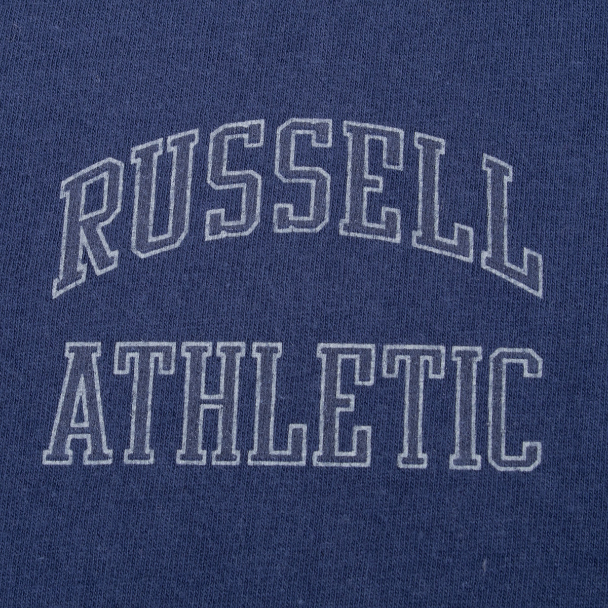 Close-up of outlined Russell Athletic chest print on navy T-shirt