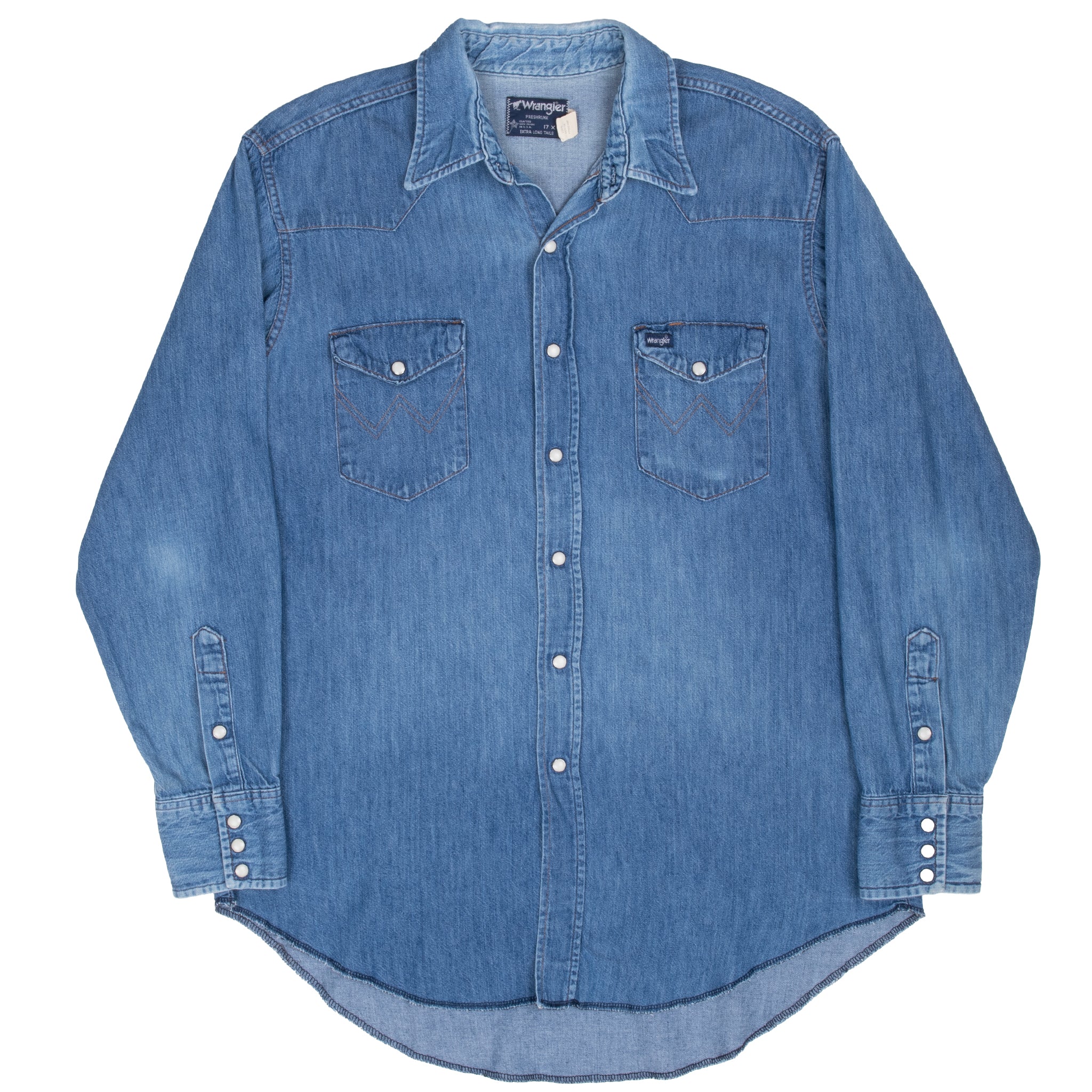 Full front view of blue Wrangler pearl snap denim shirt with long shirttail hem