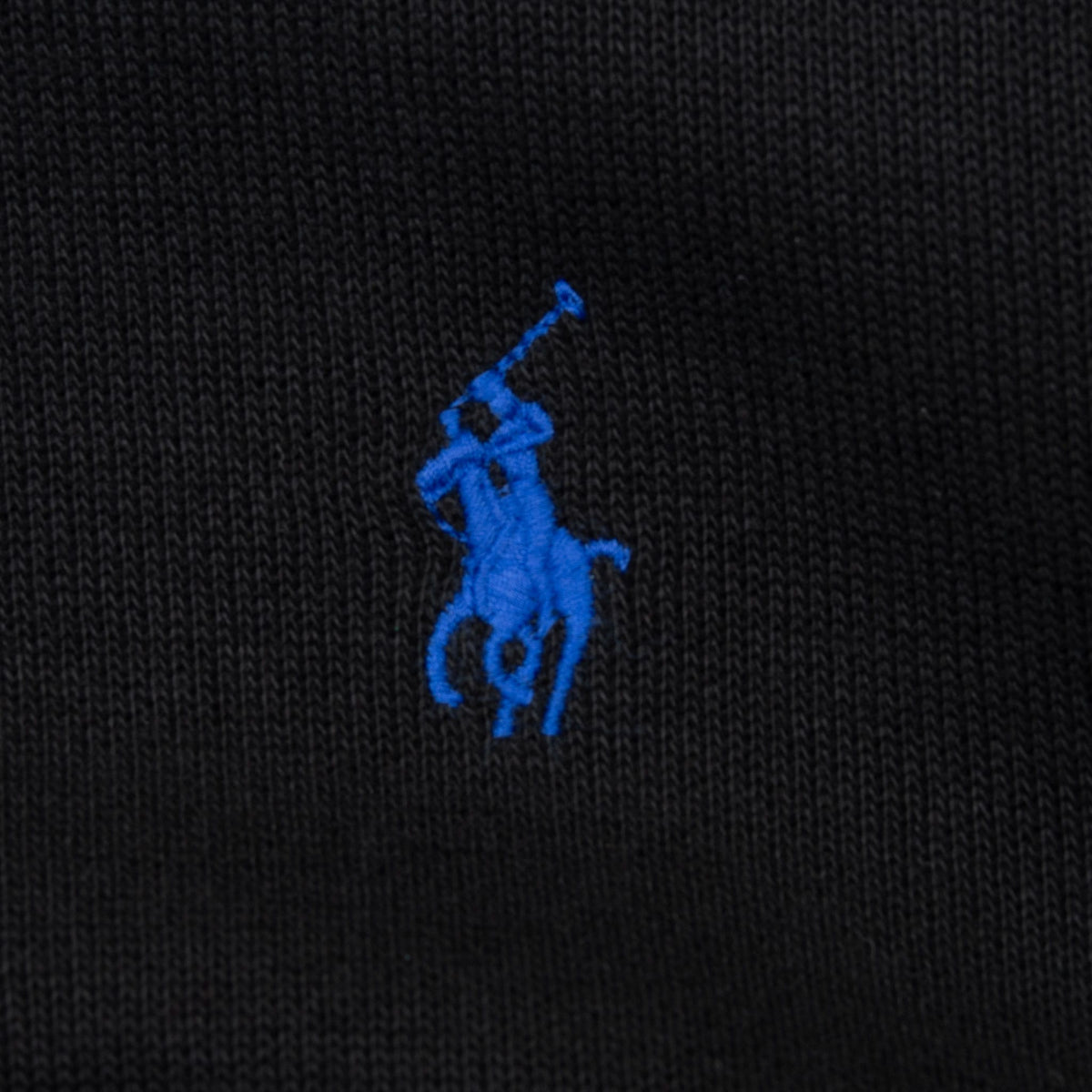 Close-up of bright blue Polo pony embroidery on black sweater