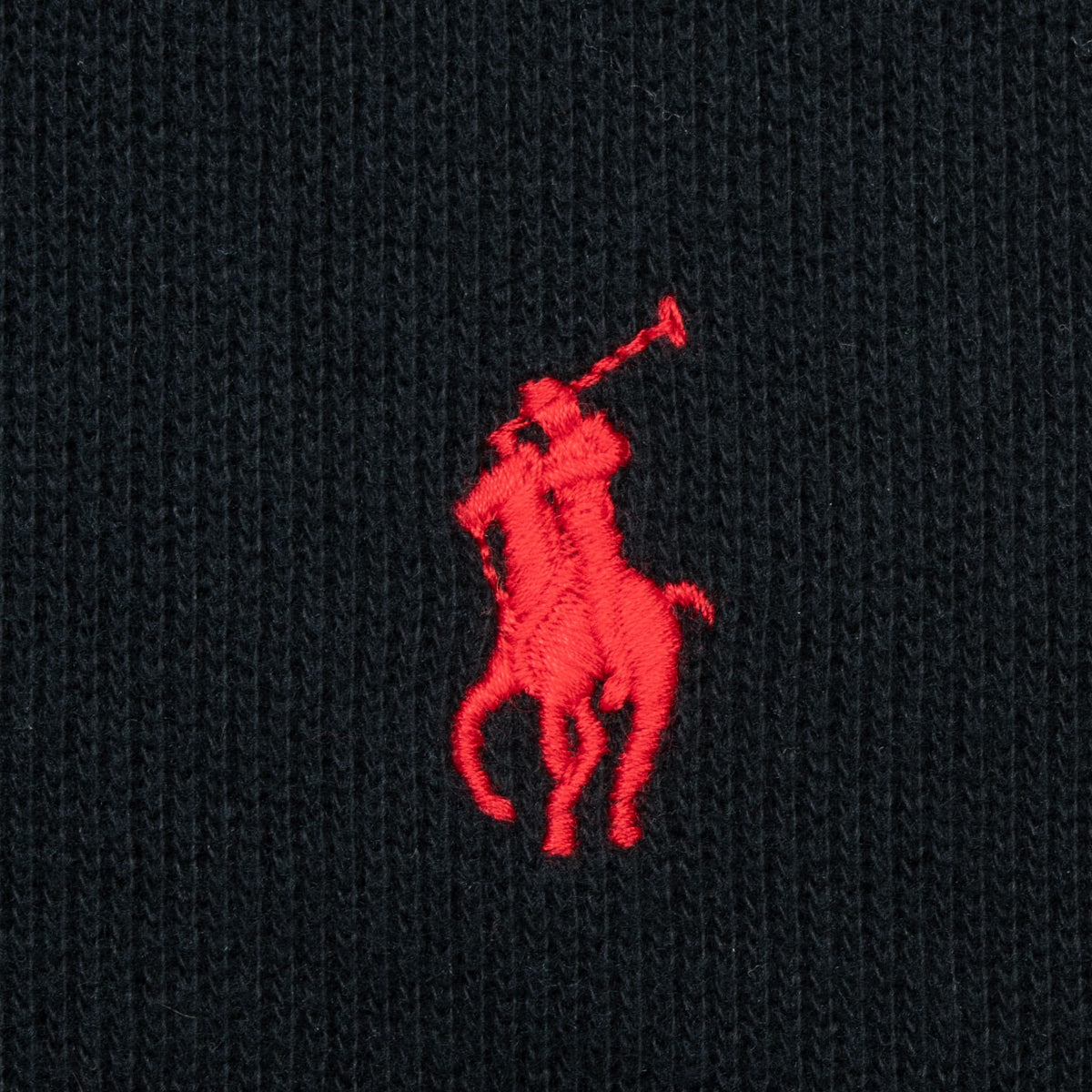 Close-up of red Polo pony embroidery on black sweater chest