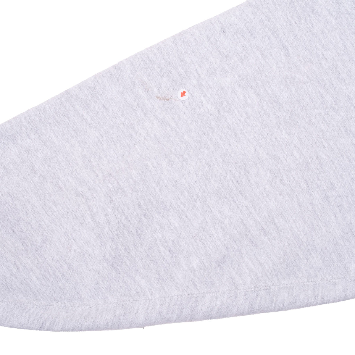 Close-up of small discolored spot on grey sweatshirt sleeve