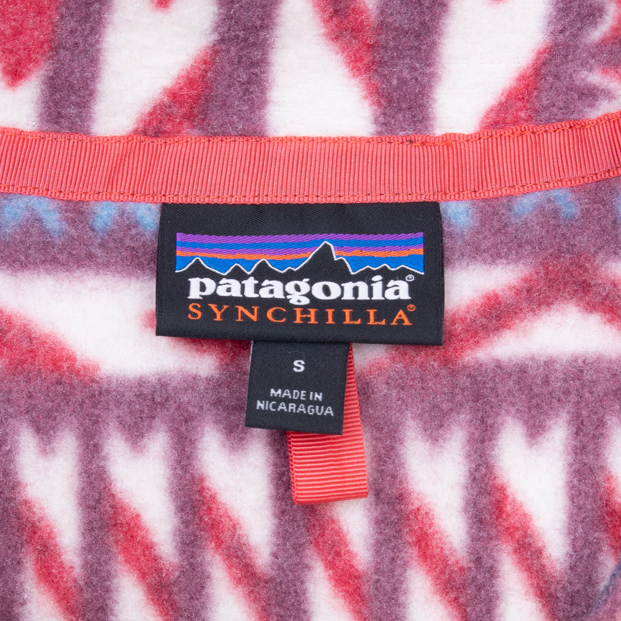 Patagonia Synchilla neck label and small size tag inside geometric-print fleece