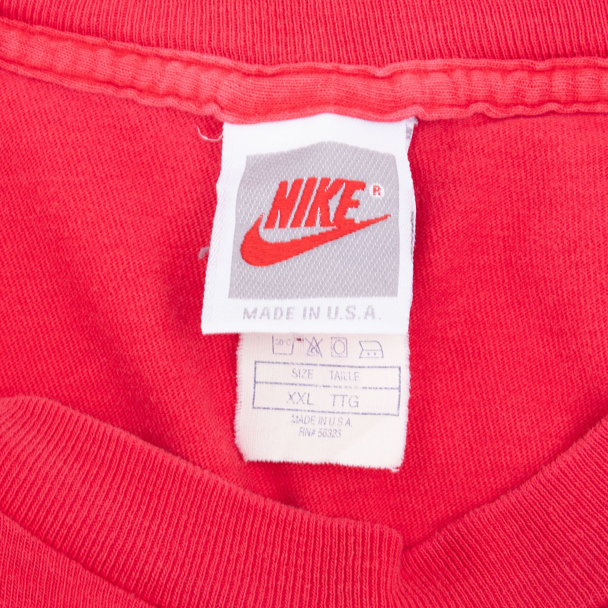 Nike neck tag on red T-shirt showing Made in USA and size XXL