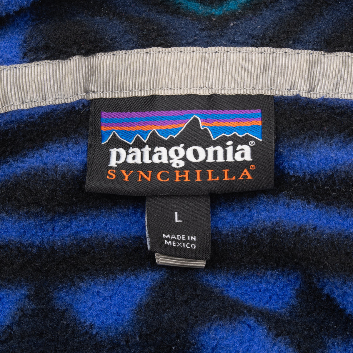 Patagonia Synchilla neck label and size L tag inside patterned fleece pullover