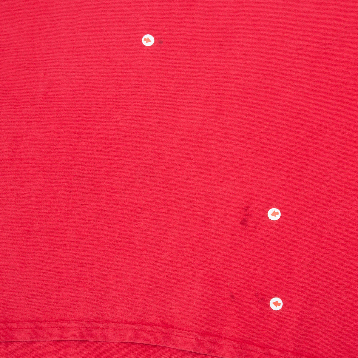 Close-up of marks near the lower hem of the red Nike T-shirt
