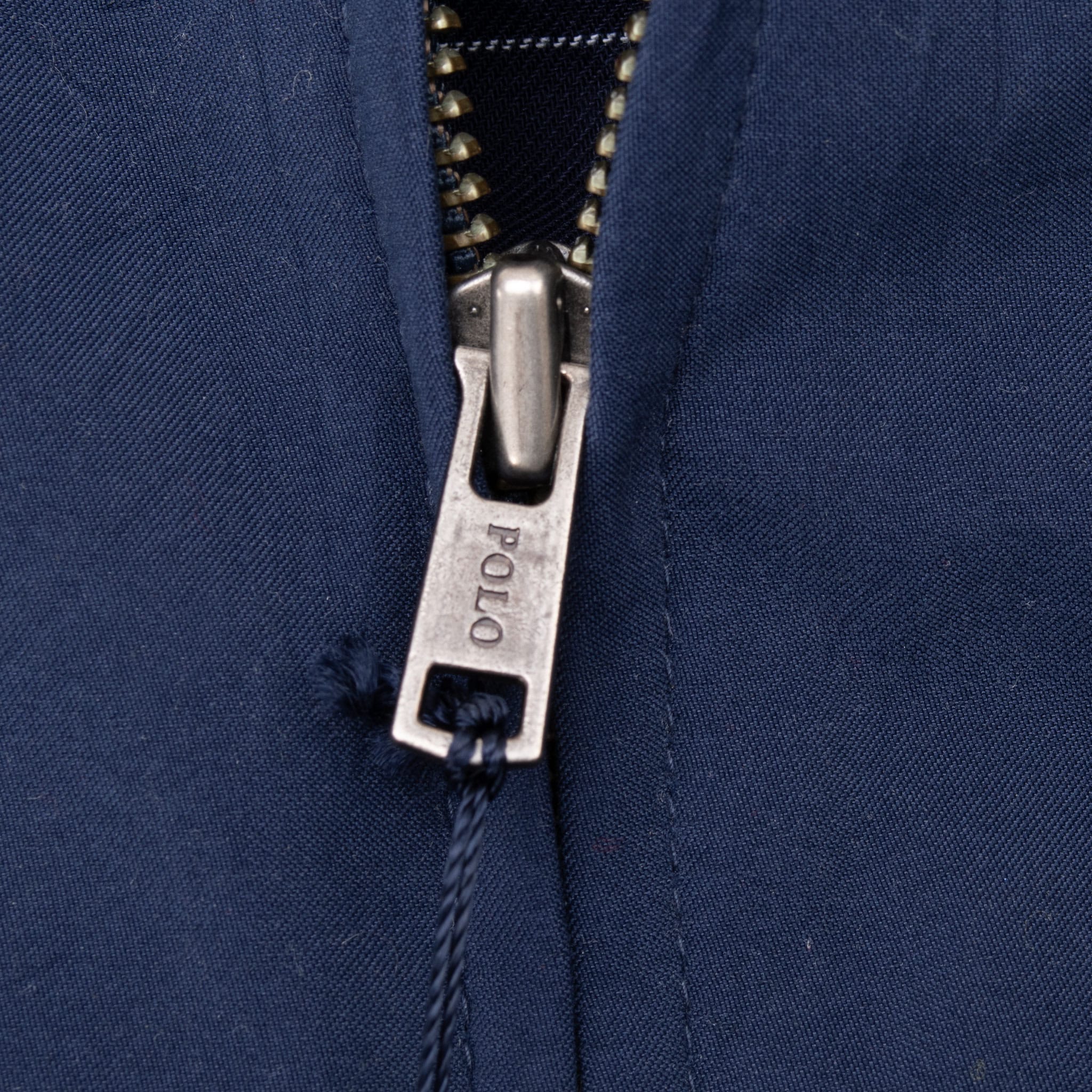 Close-up of metal Polo-engraved front zipper pull on blue jacket