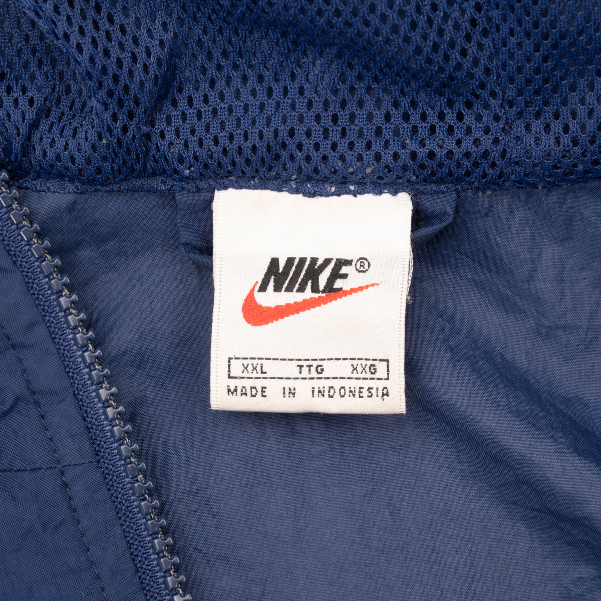 Nike neck label showing size XXL and Made in Indonesia inside blue windbreaker