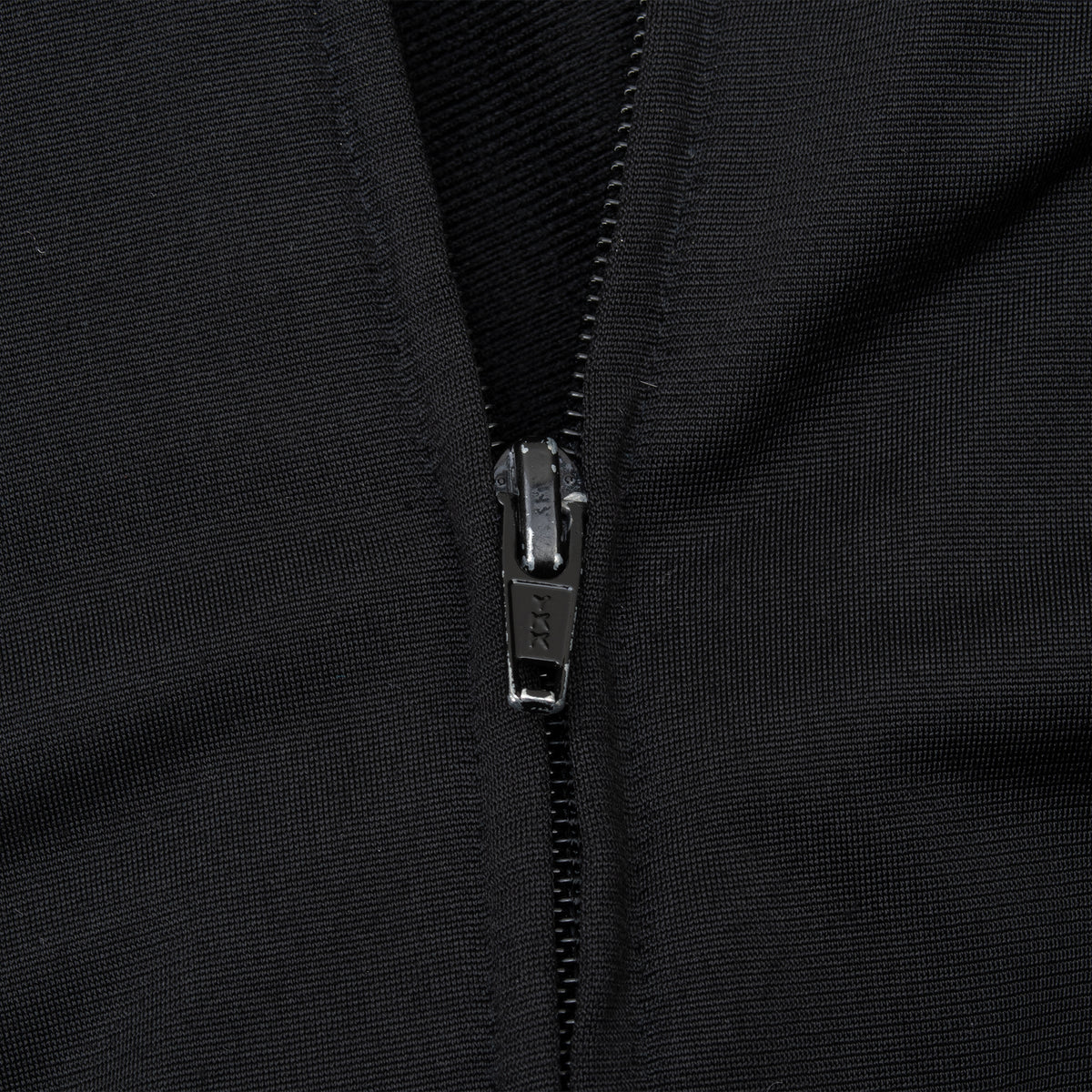 Close-up of the black front zipper on a Ralph Lauren Polo Jeans track jacket